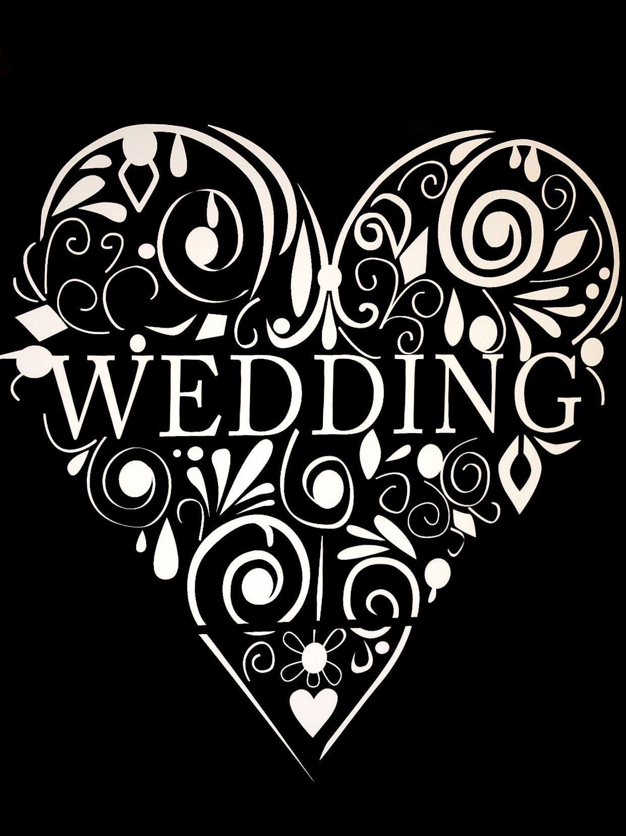 Elegant white heart-shaped wedding text design with ornate floral patterns on black background.
