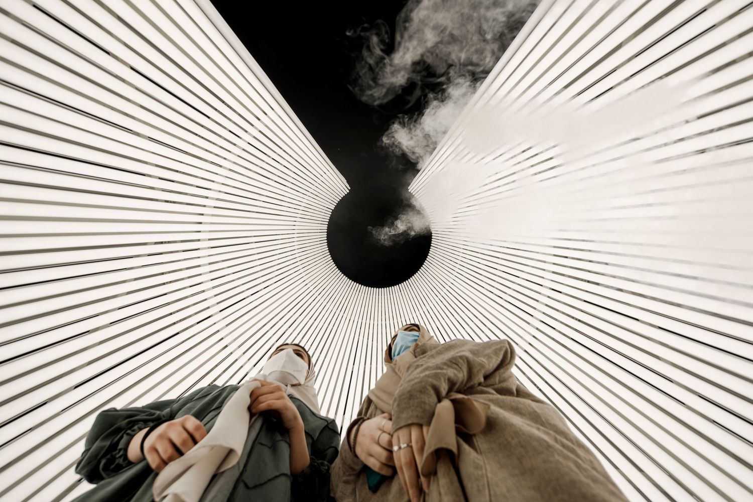 Radial lines converge on a dark center point with smoke rising above.