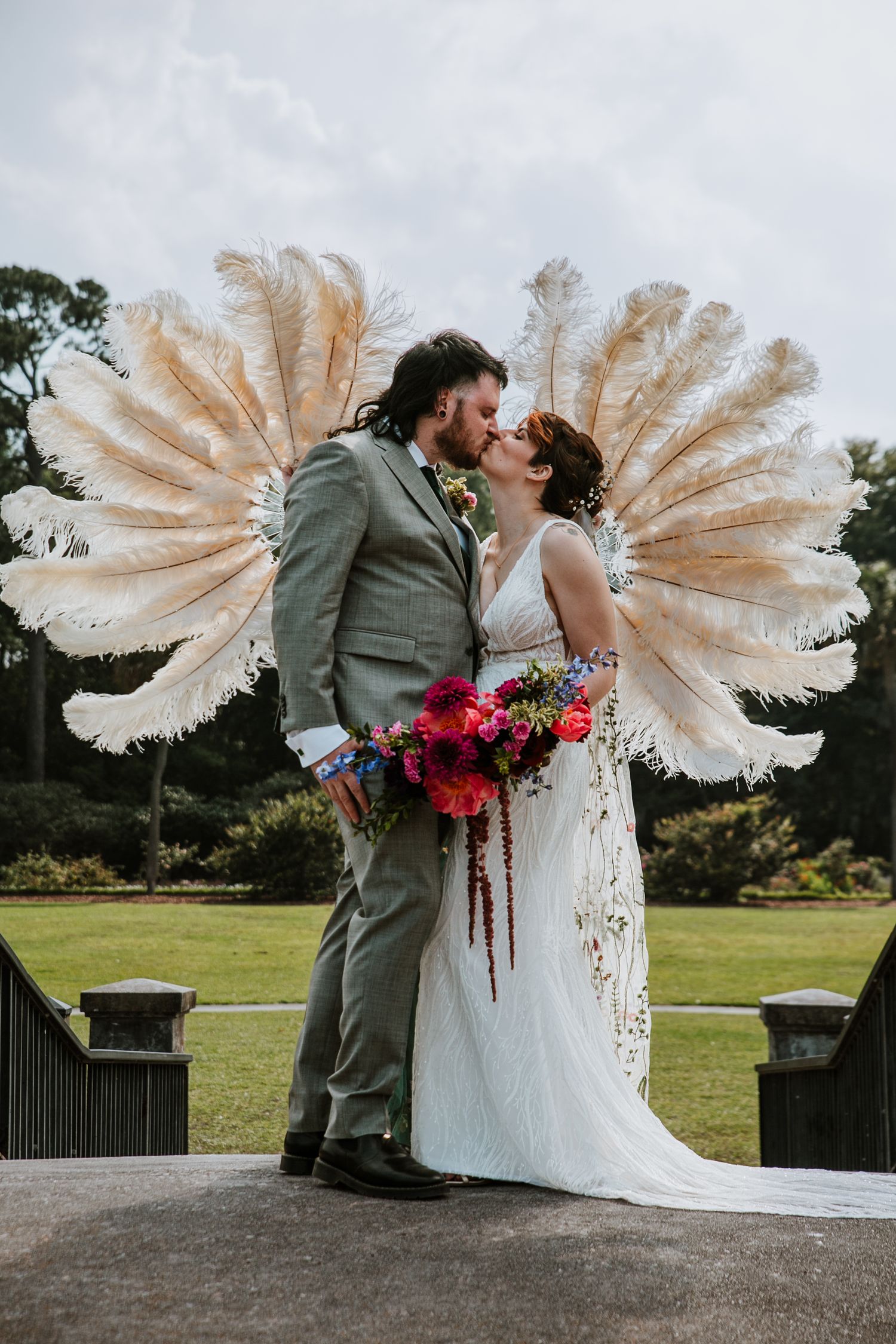 A couple shares a kiss in Hampton Park with a unique feathered background