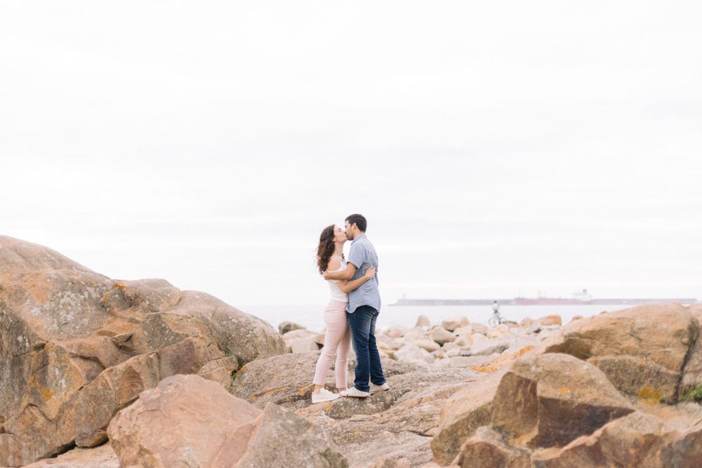 casal abraçado nas rochas na praia do castelo do queijo em matosinhos