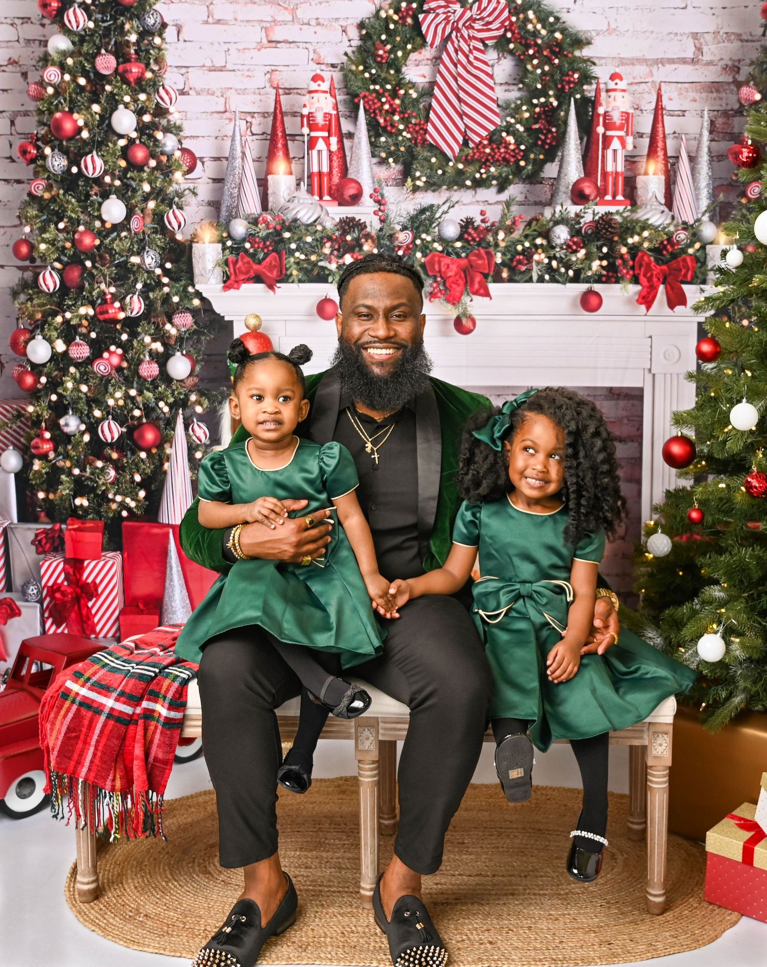 Festive Christmas scene with decorated trees and fireplace mantel with holiday decor.