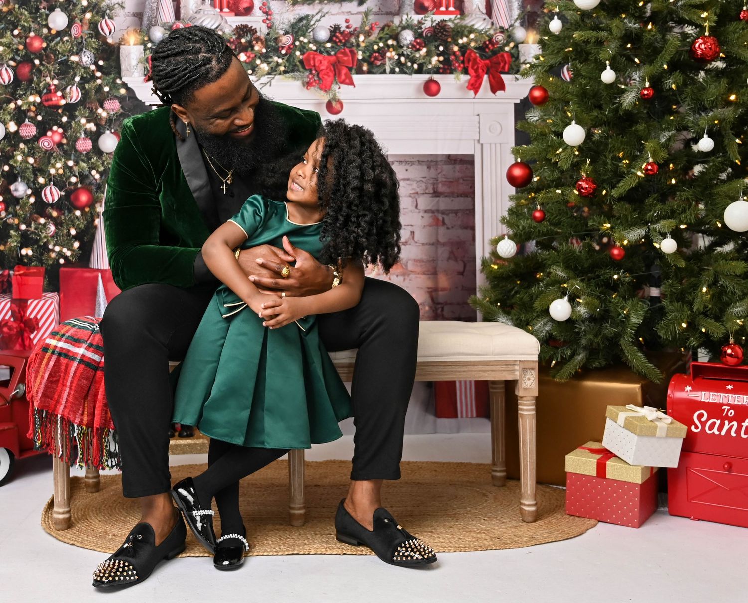 Sweet holiday moment captured in front of a decorated Christmas tree and fireplace.