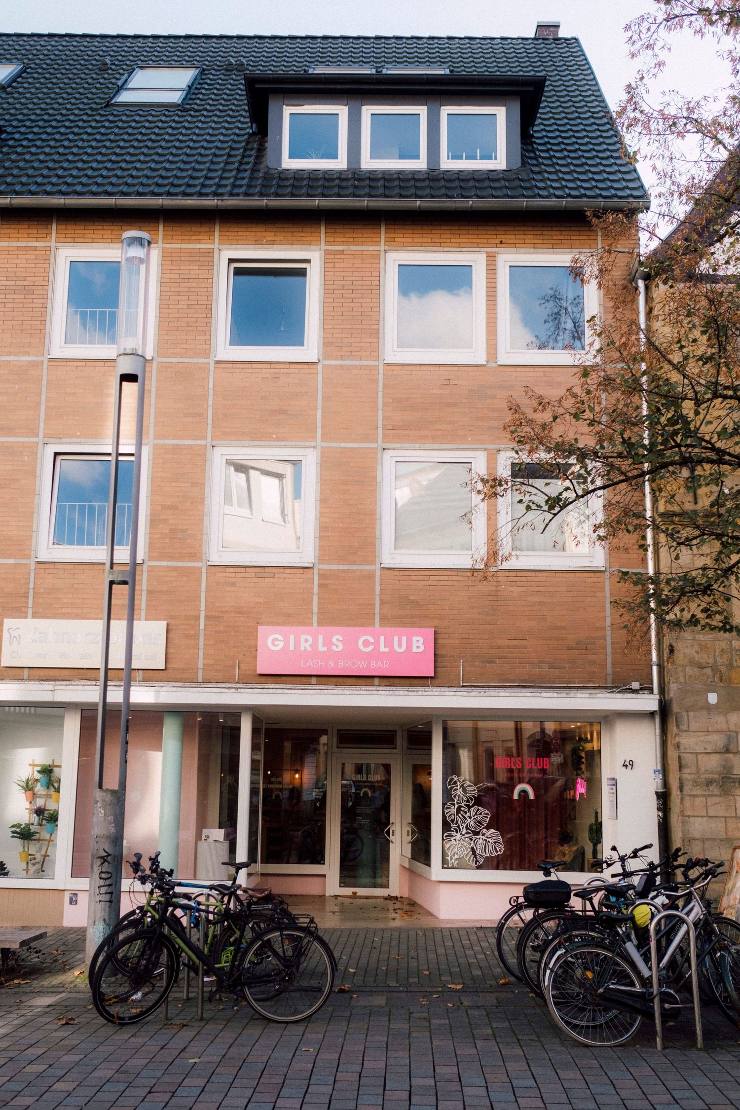Row of brick buildings with bicycles parked outside and Girls Club signage.