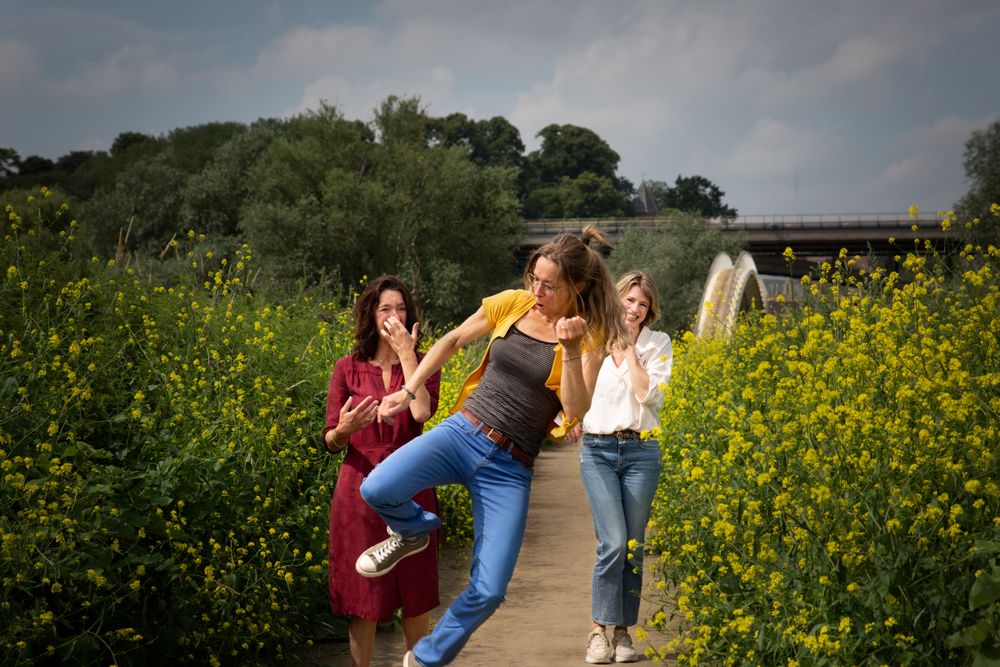 Drie vrouwen hebben samen plezier in een kleurrijk bloemenveld – familiefotografie Nijmegen