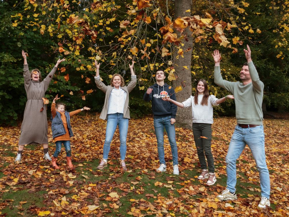 Spontane groepsfoto met familie tussen de herfstbomen – familieshoot Arnhem