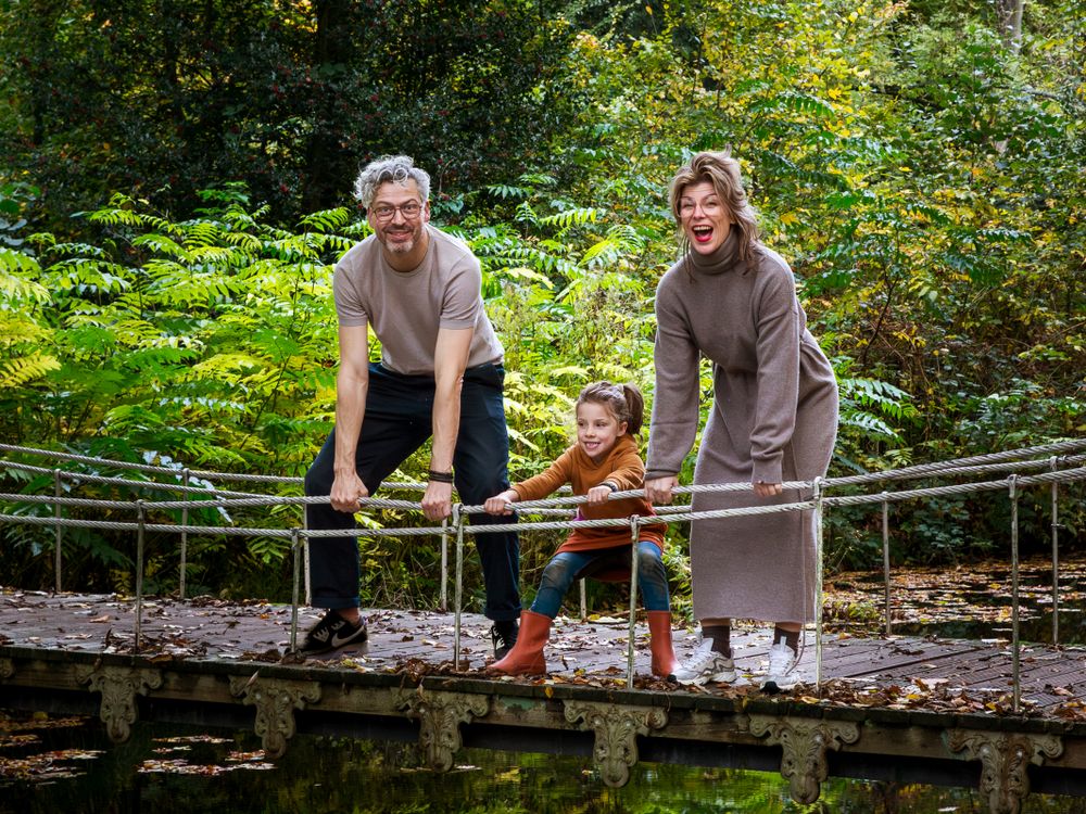 Spontaan gezin met kind op een houten bruggetje in het bos – familiefotografie Gelderland