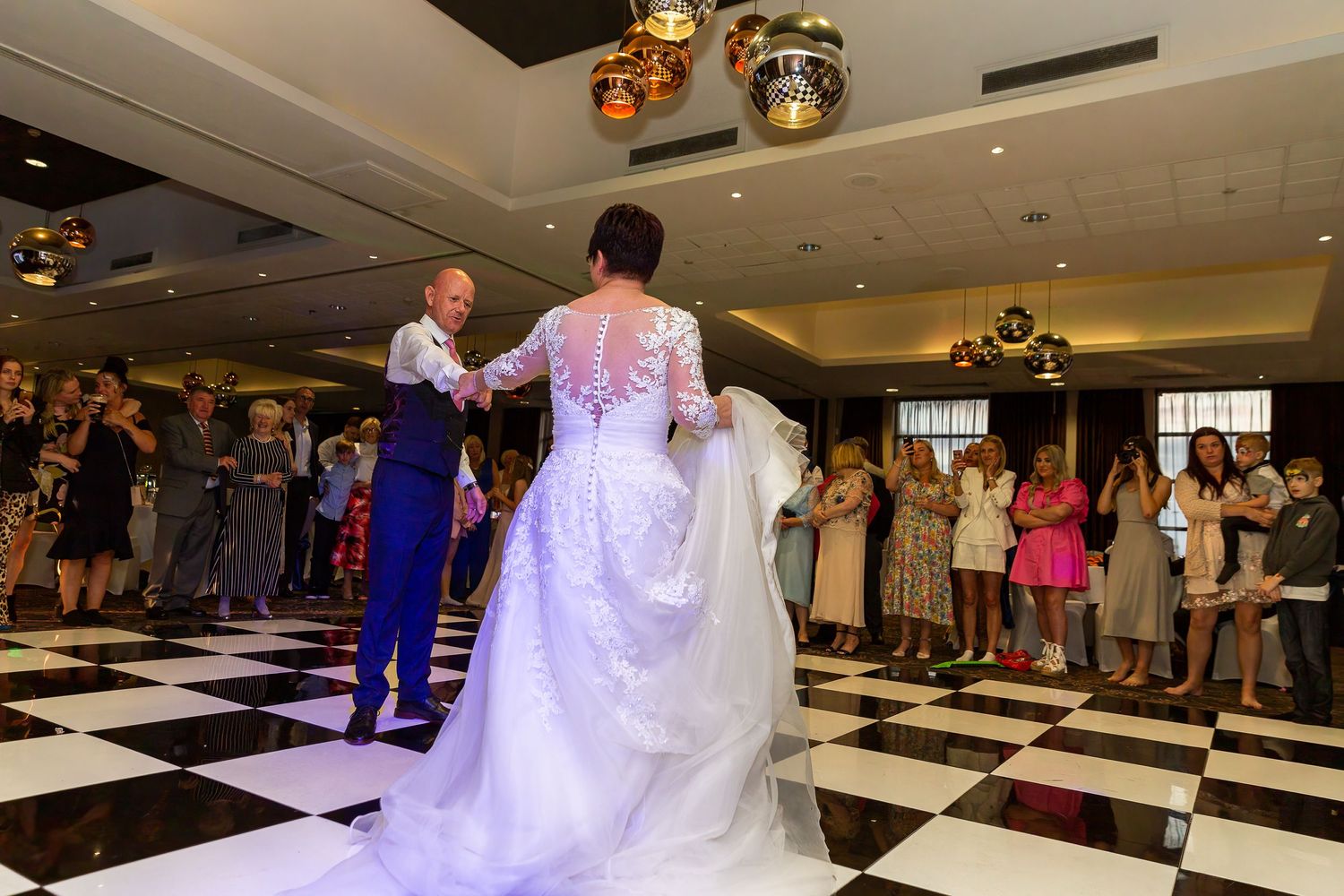 Bride and groom during the first dance watched by their guests. Liverpool wedding photographer Stuart Morris Photography