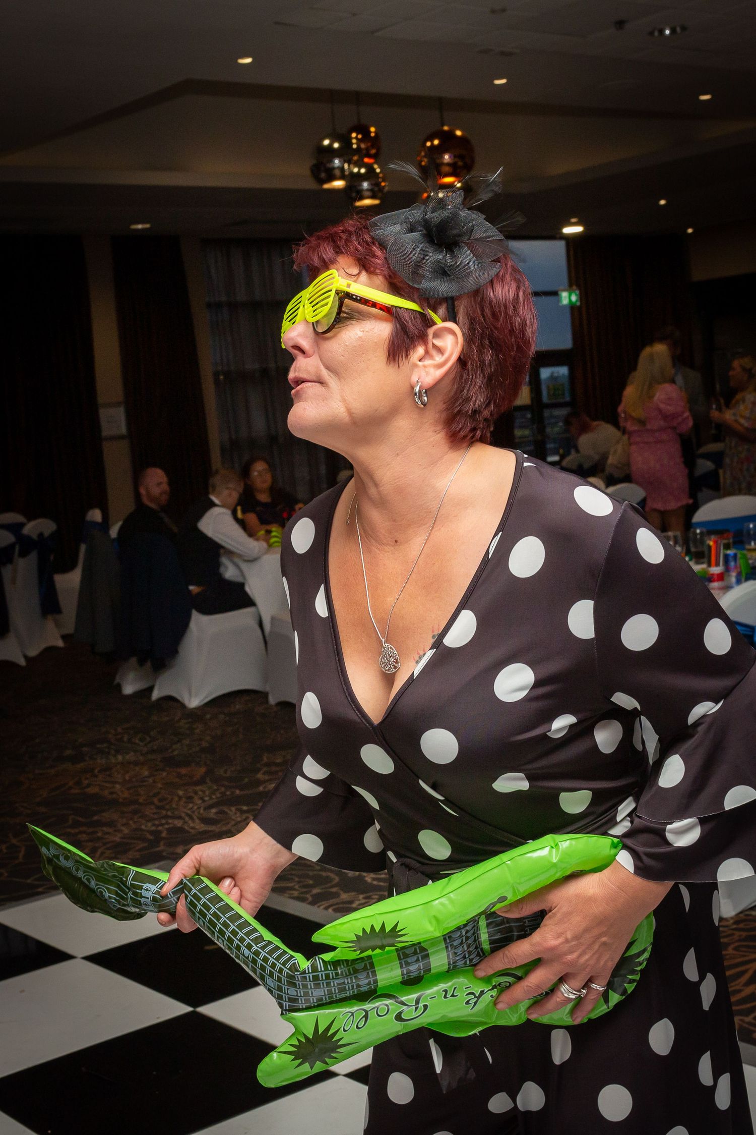 Wedding Guest enjoying herself playing an inflatable guitar on the dancefloor. Liverpool city centre wedding photography