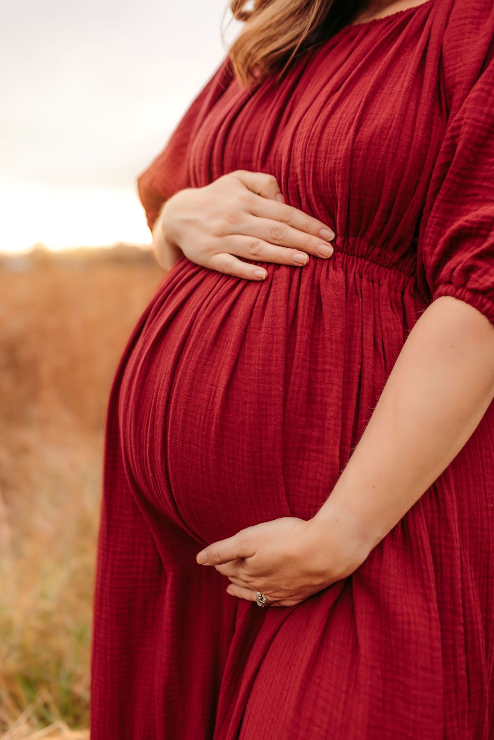 Close up of pregnant belly during natural light maternity photo session Iron Station NC