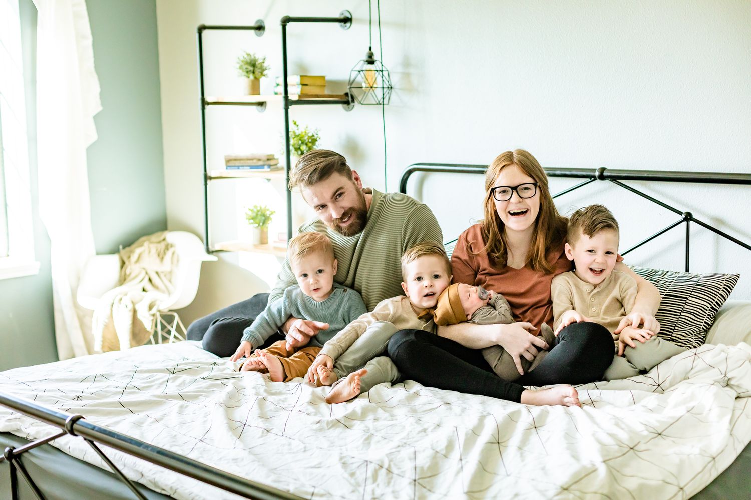 Mom, Dad, and their four sons snuggle on their bed in Monument, Colorado.