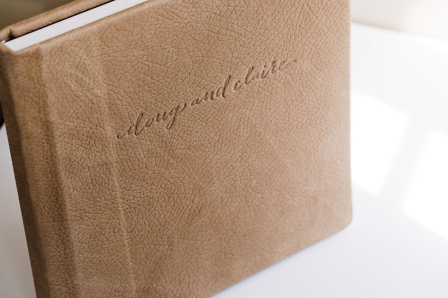 A leather-bound photo album with 'Congratulations' embossed in script text on the beige cover.