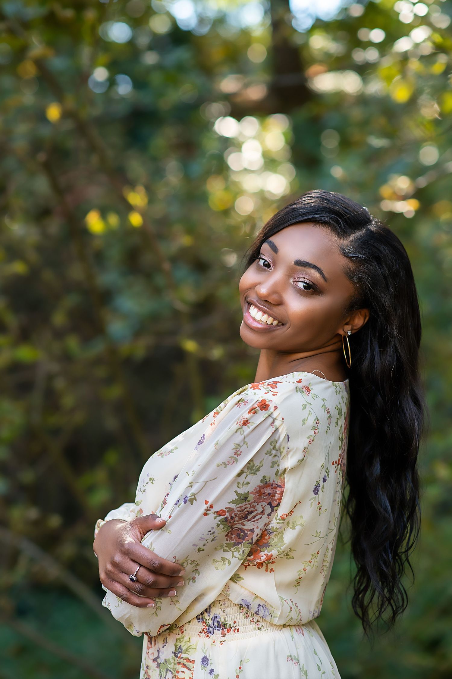 Natural light portrait session in a lush garden setting with soft bokeh background.