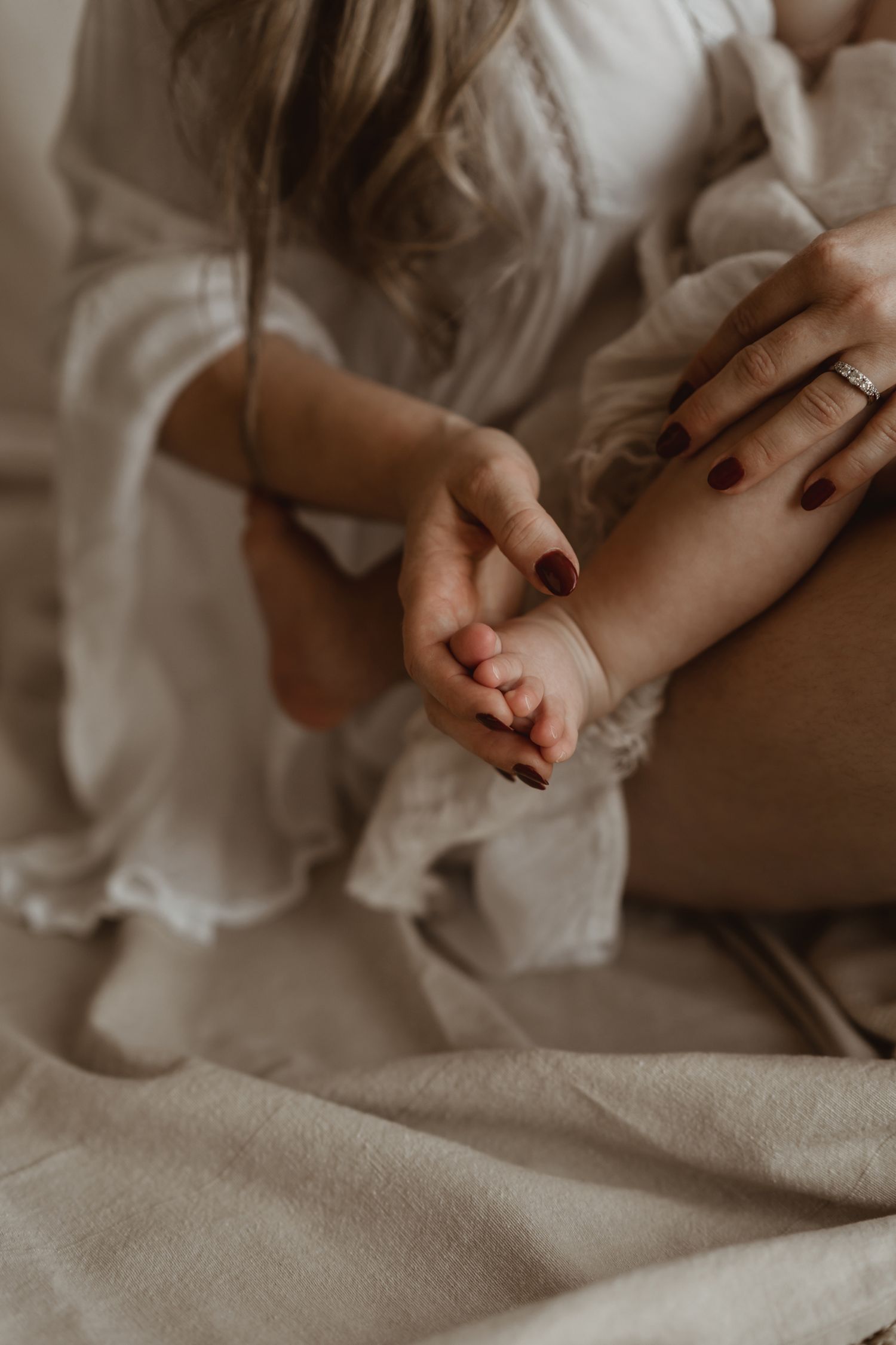 Closeup of gentle hands holding in intimate moment against light background.
