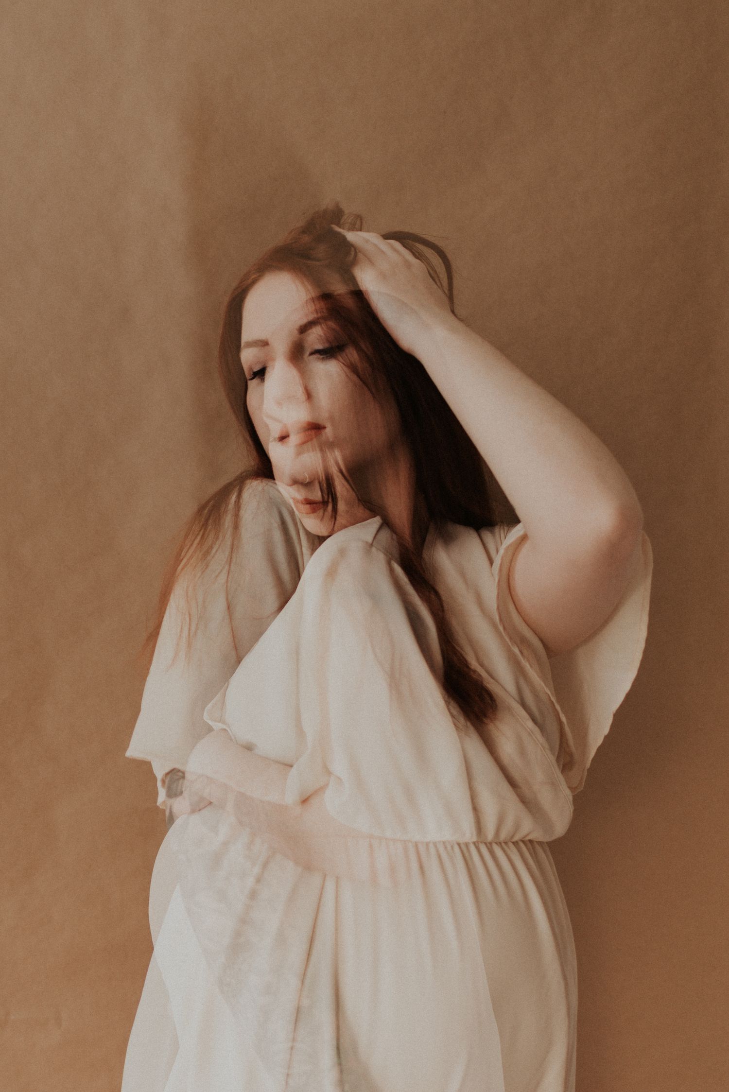 Ethereal portrait in warm tones featuring a white flowing dress.
