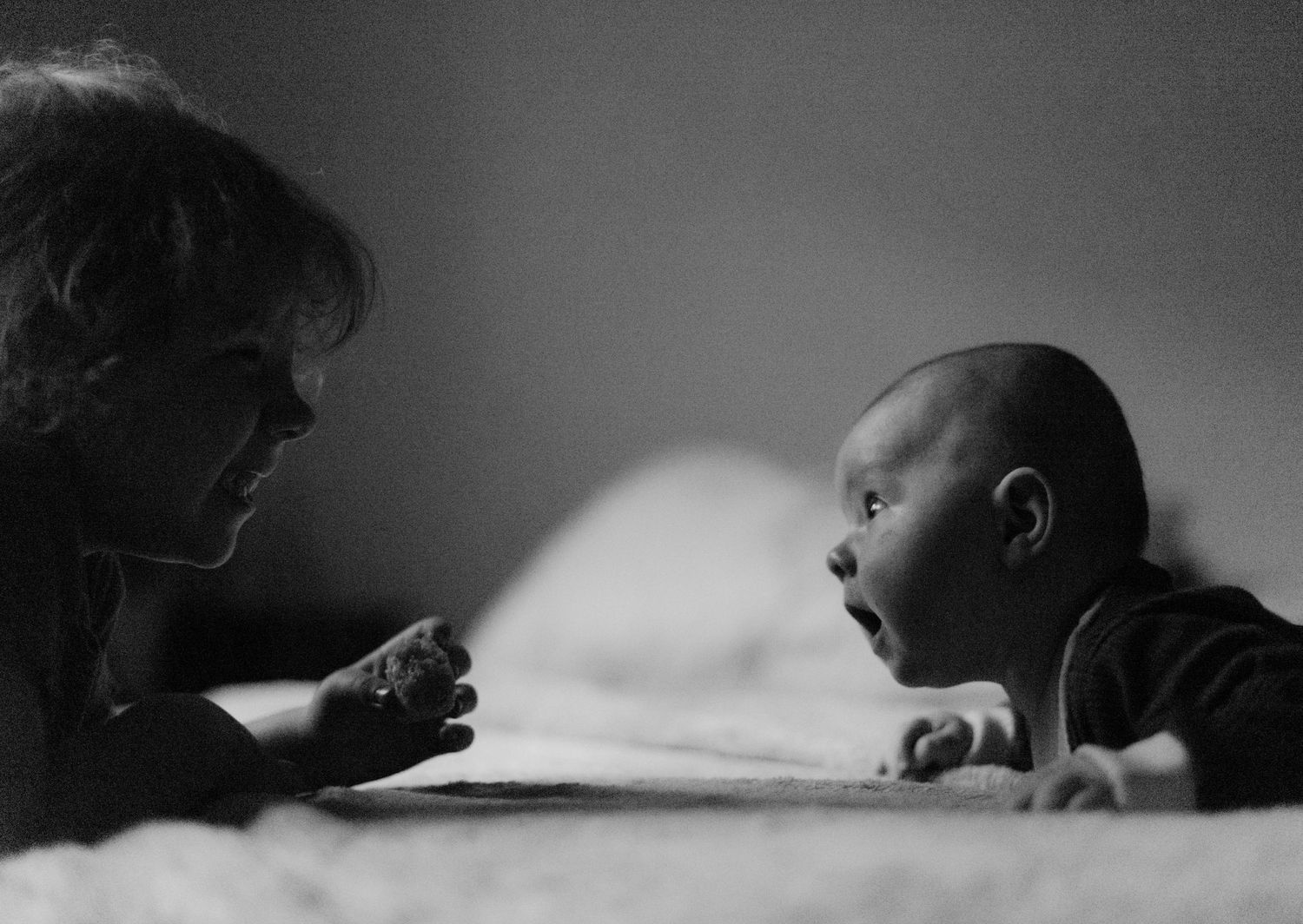 Intimate black and white photograph capturing a feeding moment with infant.