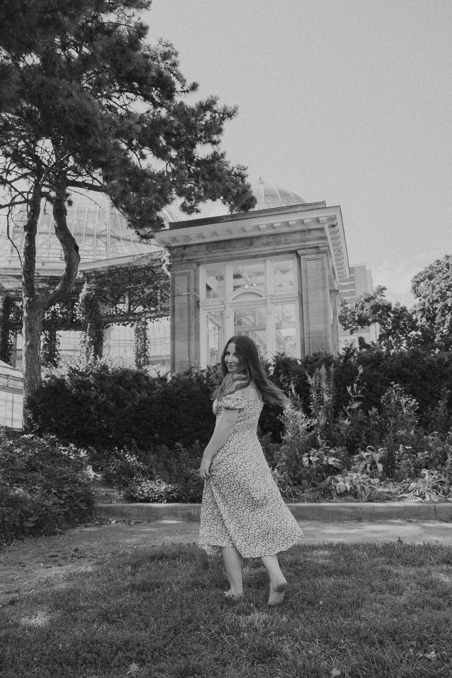 Person in a polka dot dress twirling in front of a classical architecture structure.