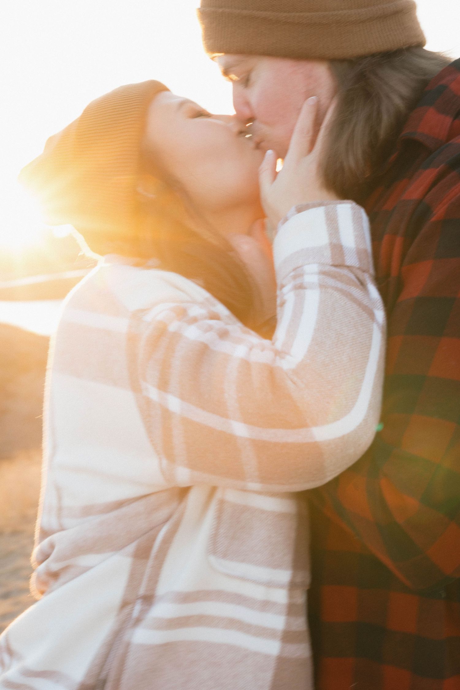 Intimate sunset portrait of couple in winter clothing with golden light.