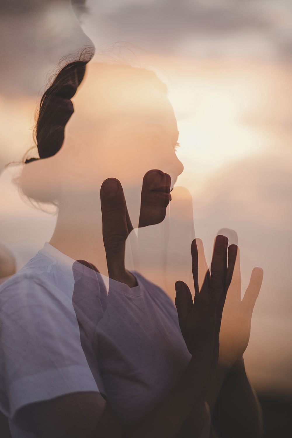 woman holding her hands in a prayer position during her holistic branding photo session in Silverstrand, Galway during sunrise