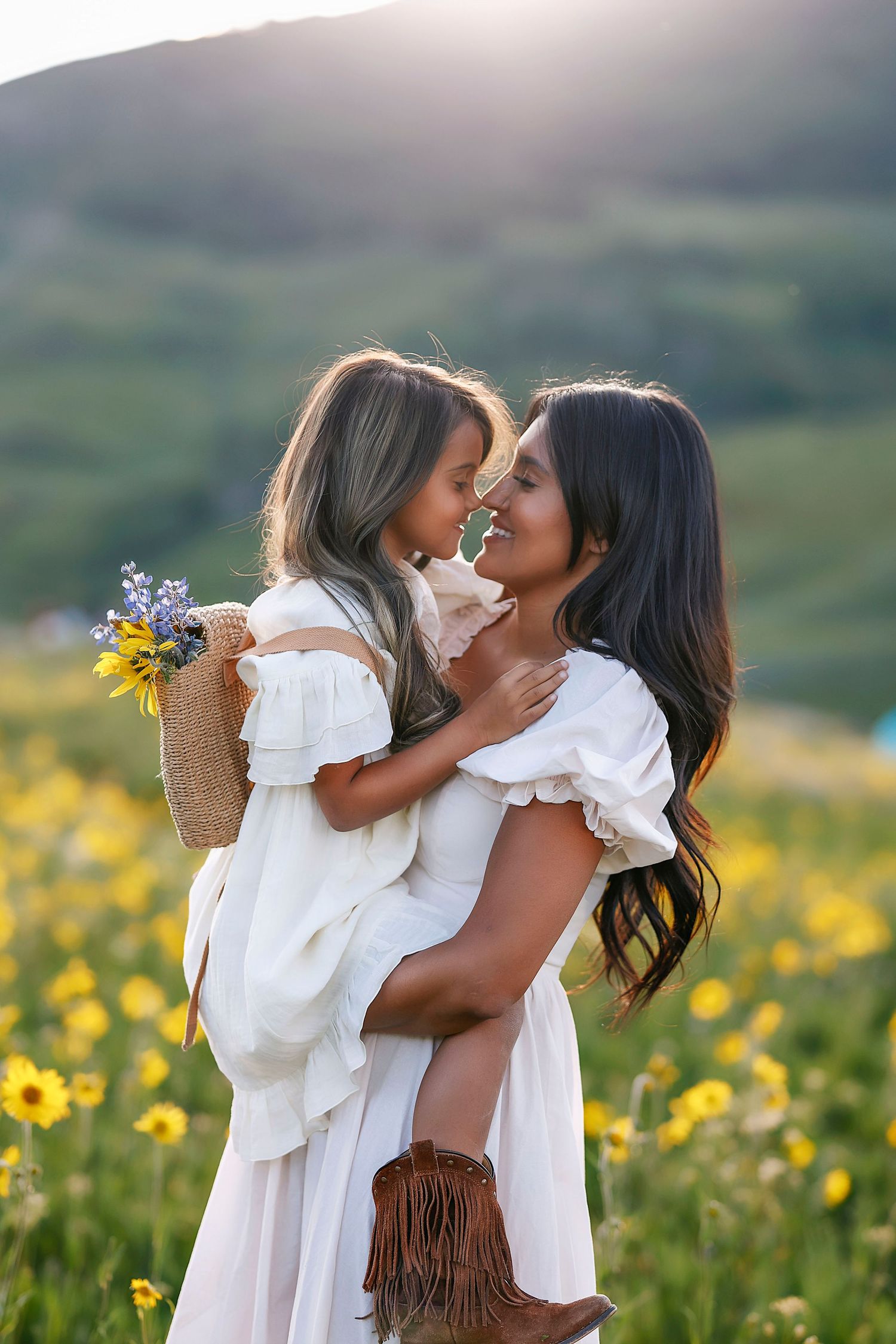 A mom nose kisses her adorable daughter in the flower fields in Crested Butte, Colorado.