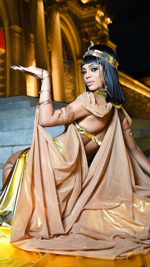 Dramatic ancient Egyptian themed portrait on grand staircase with flowing fabrics.