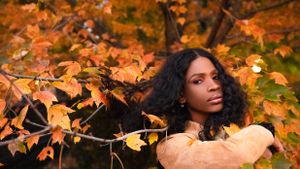 Portrait in warm autumn setting with vibrant orange leaves and natural lighting.
