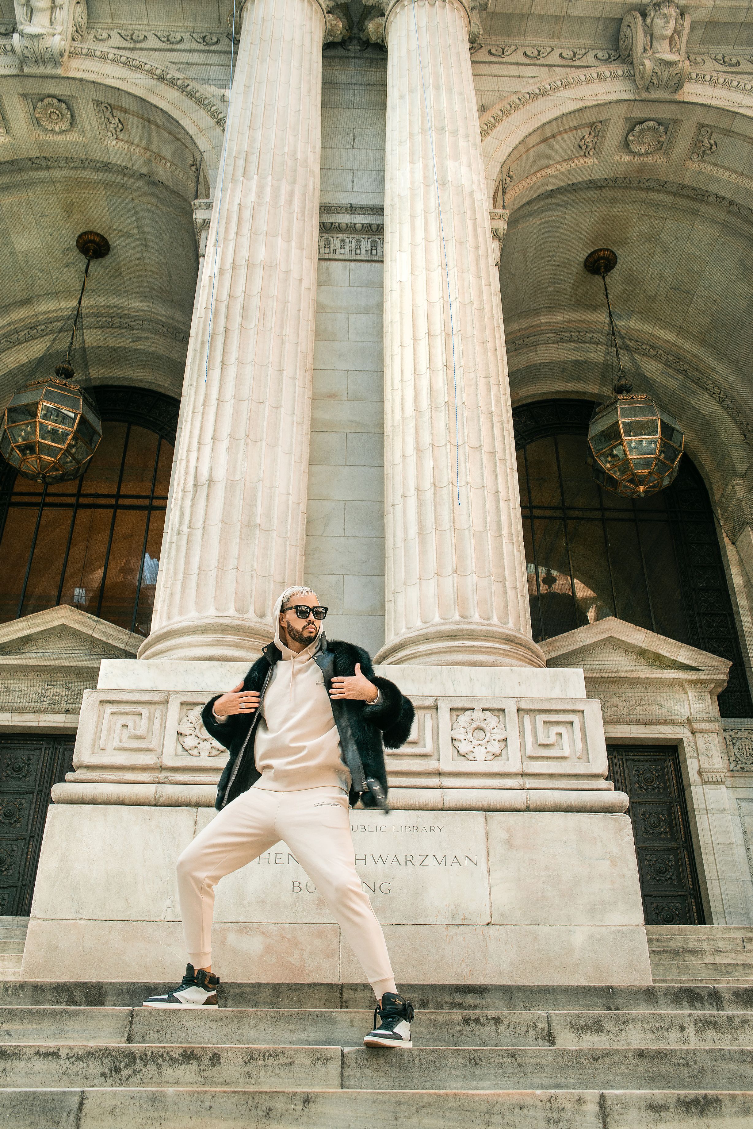 Stylish pose against neoclassical architecture with grand columns and ornate details.