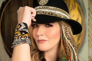 Close-up shot of decorative black hat with beaded embellishments and feather details.