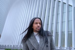 Grey winter coat look against modern white architectural background.