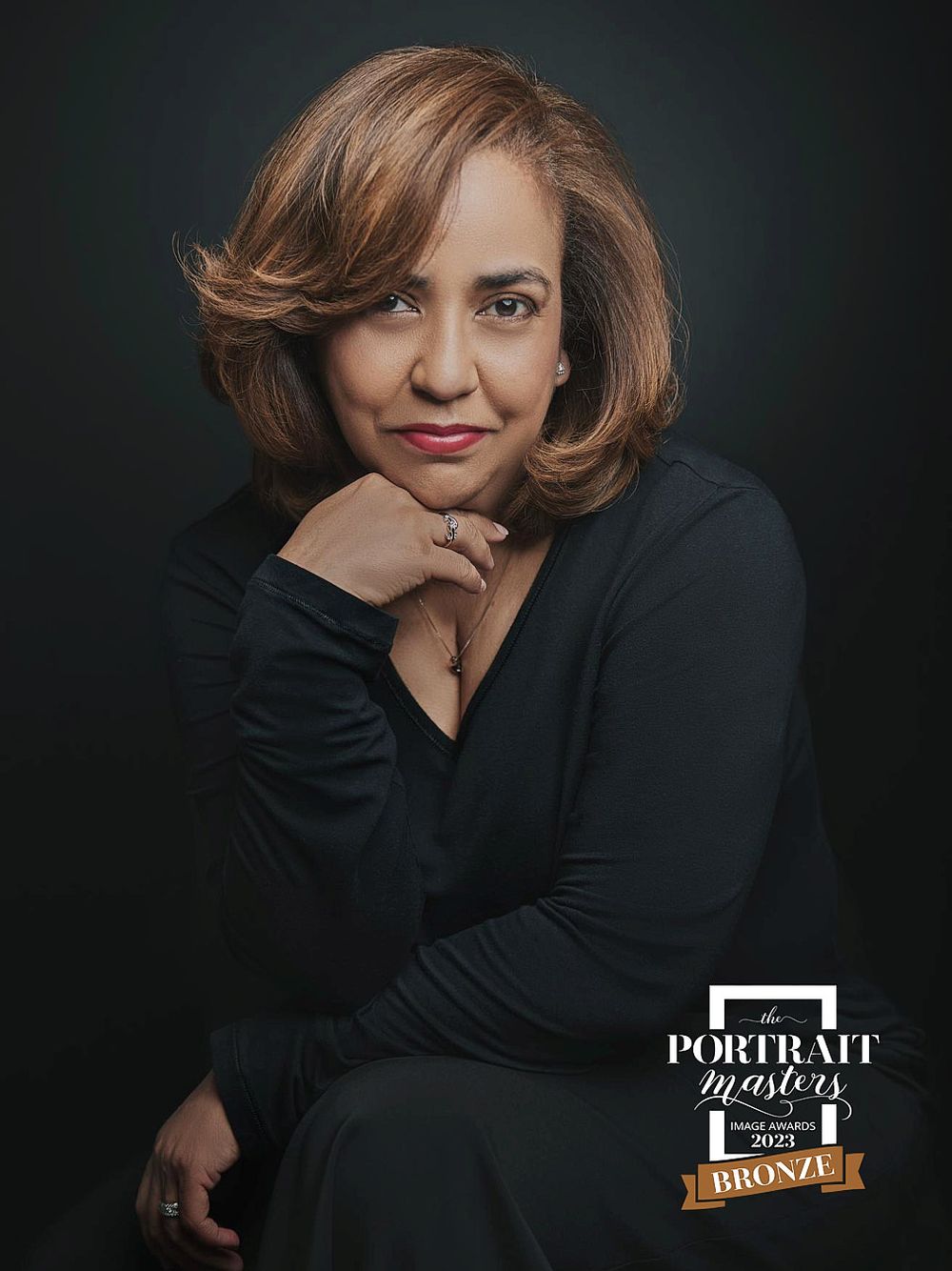 Elegant woman in black dress seated gracefully, Portrait Masters 2023 Bronze award winning portrait.