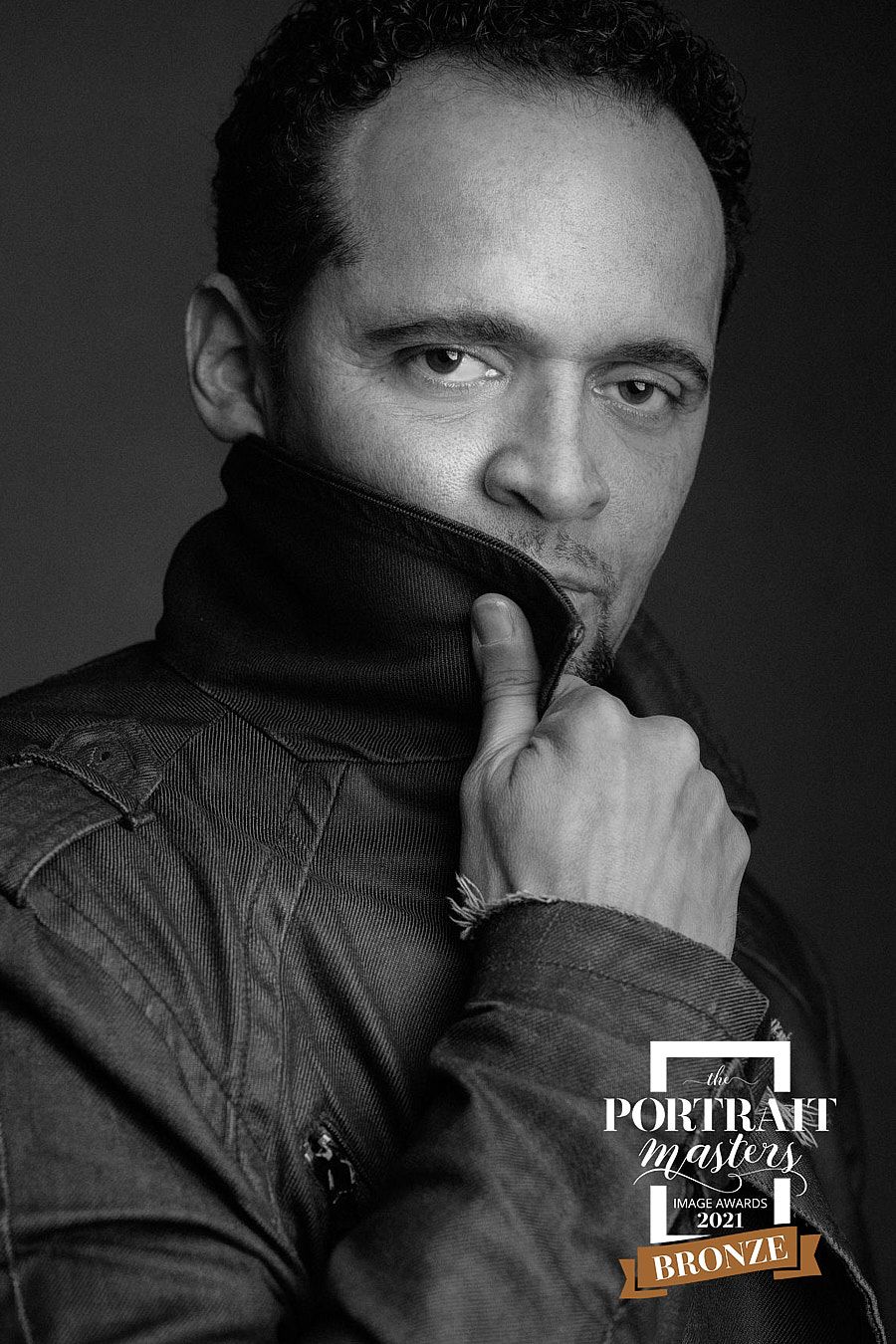 Black and white portrait of man in turtleneck jacket, Portrait Masters 2021 Bronze award winner.