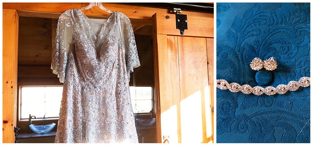 Silver lace wedding dress hanging in rustic barn with blue floral earrings detail shot.