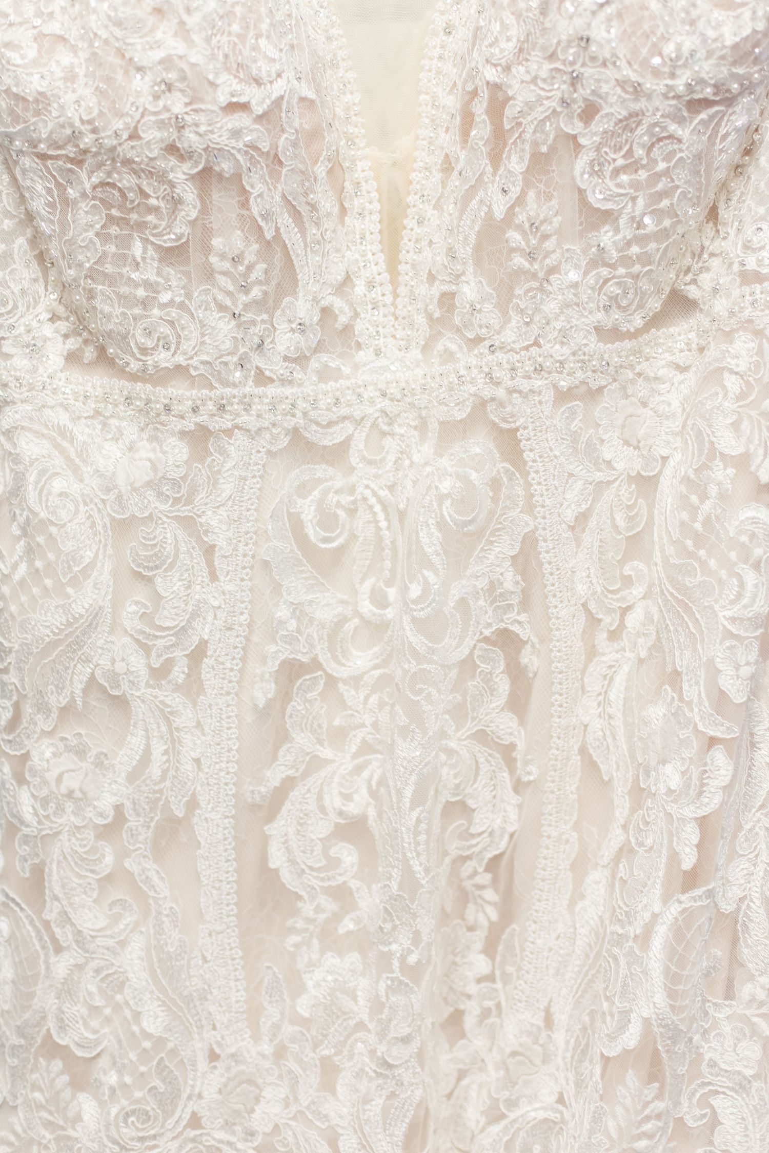 Intricate floral lace pattern detail on an ivory wedding dress.