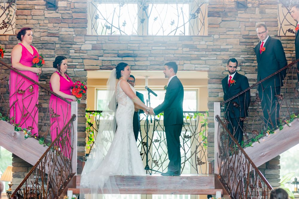 Wedding ceremony with couple at center and wedding party on stone staircase.