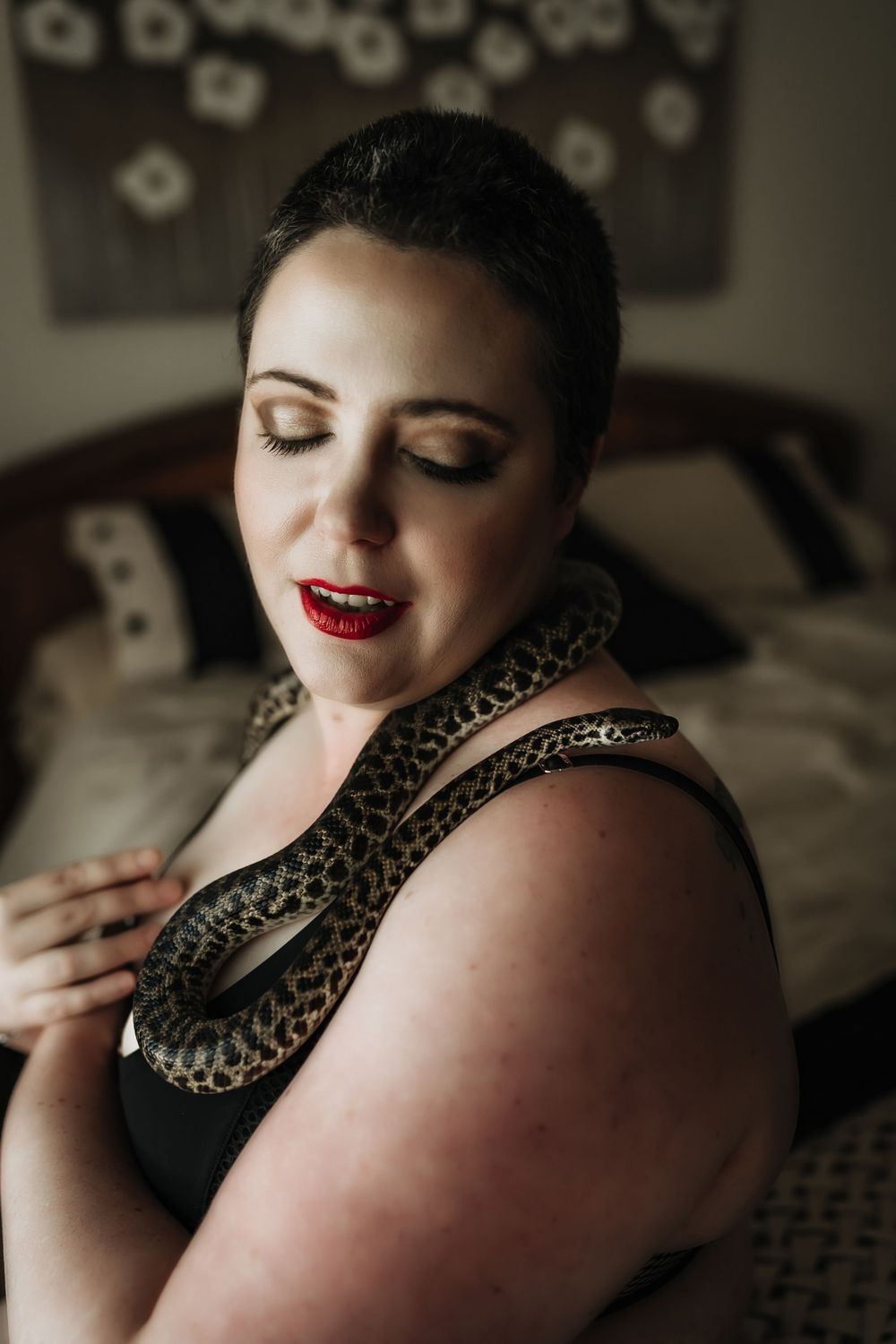 short haired woman in glamour makeup wearing lingerie with snake on shoulder