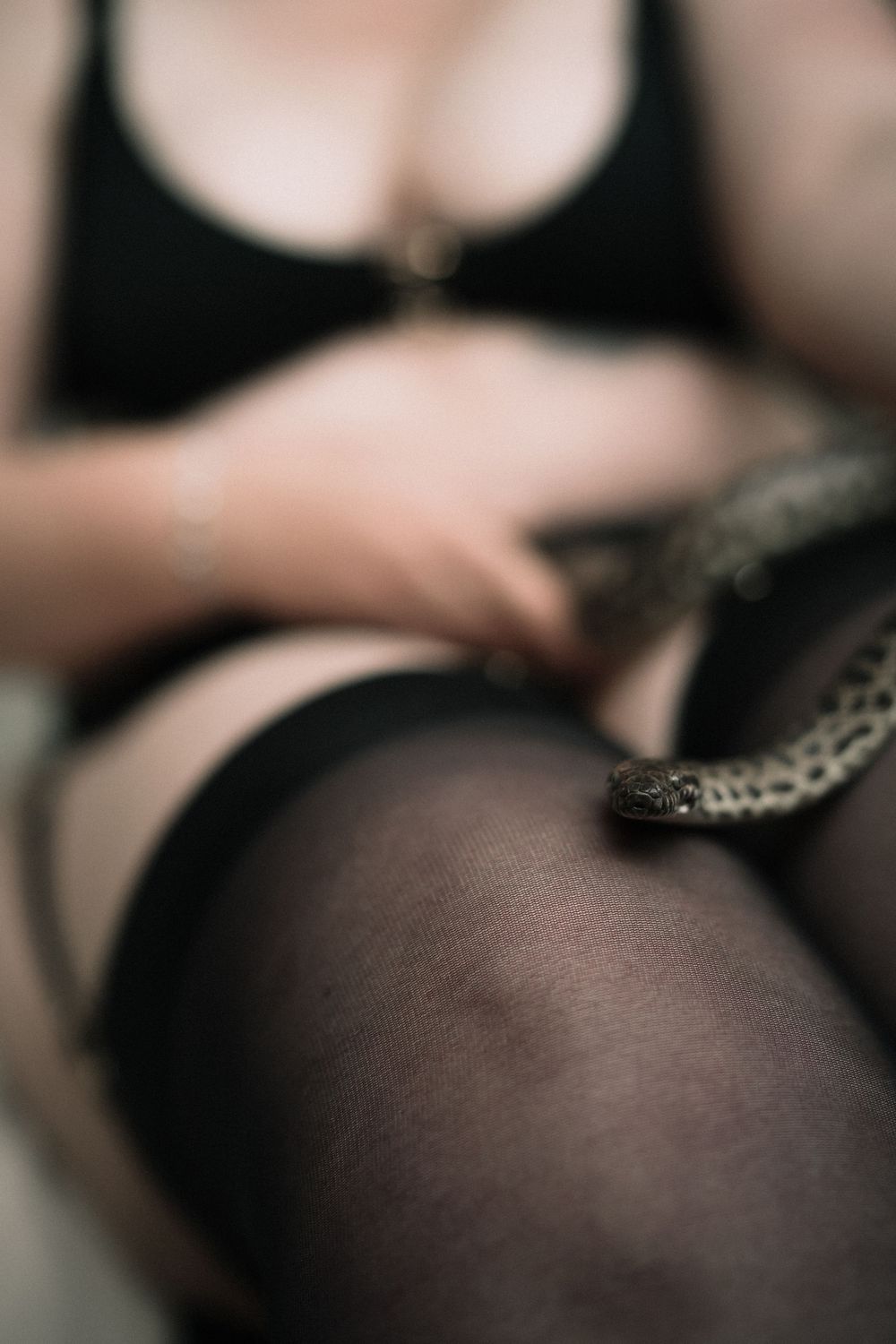 plus size woman in black stockings with snake on legs