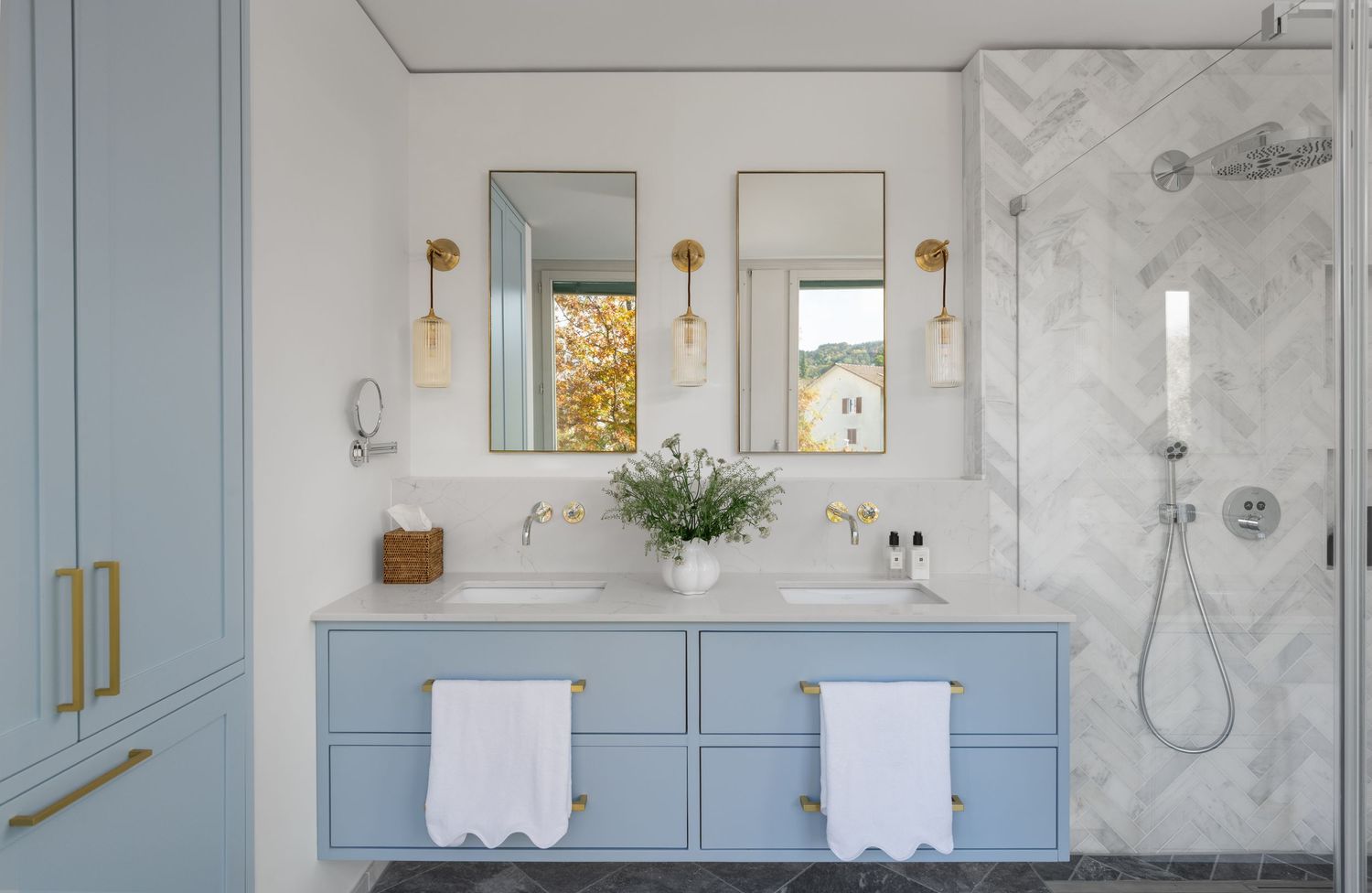 A blue bathroom cabinet with two sinks and gold features