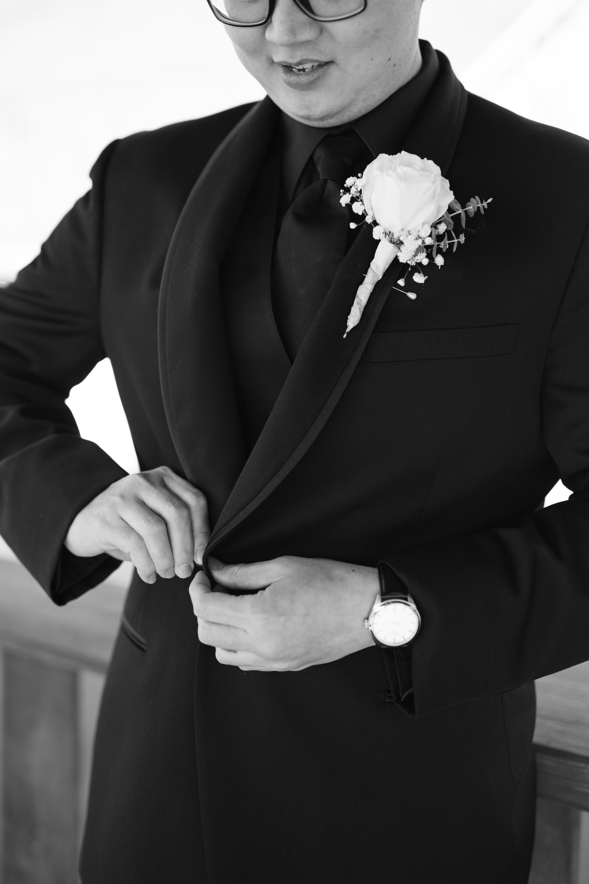 Wedding preparation showing formal black suit with white boutonniere.