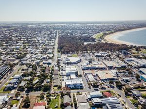 Expansive aerial view of coastal city showing urban development and beachfront areas.