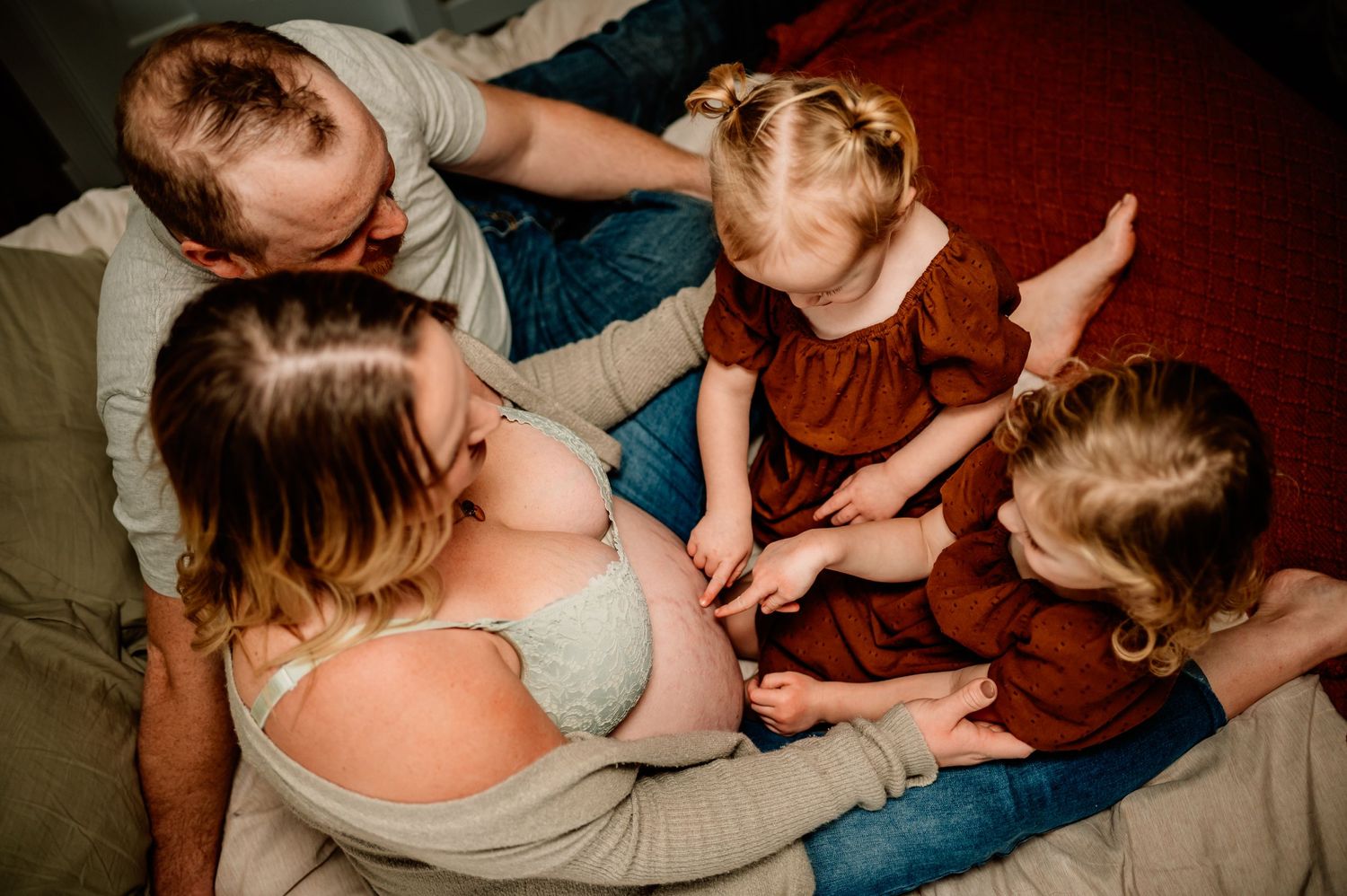 Family lying together on floor sharing intimate bonding moment.