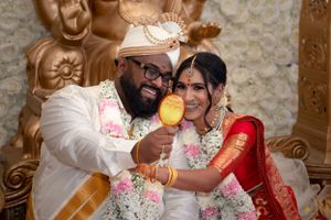 Joyful wedding moment with couple in traditional attire sharing a playful pose.