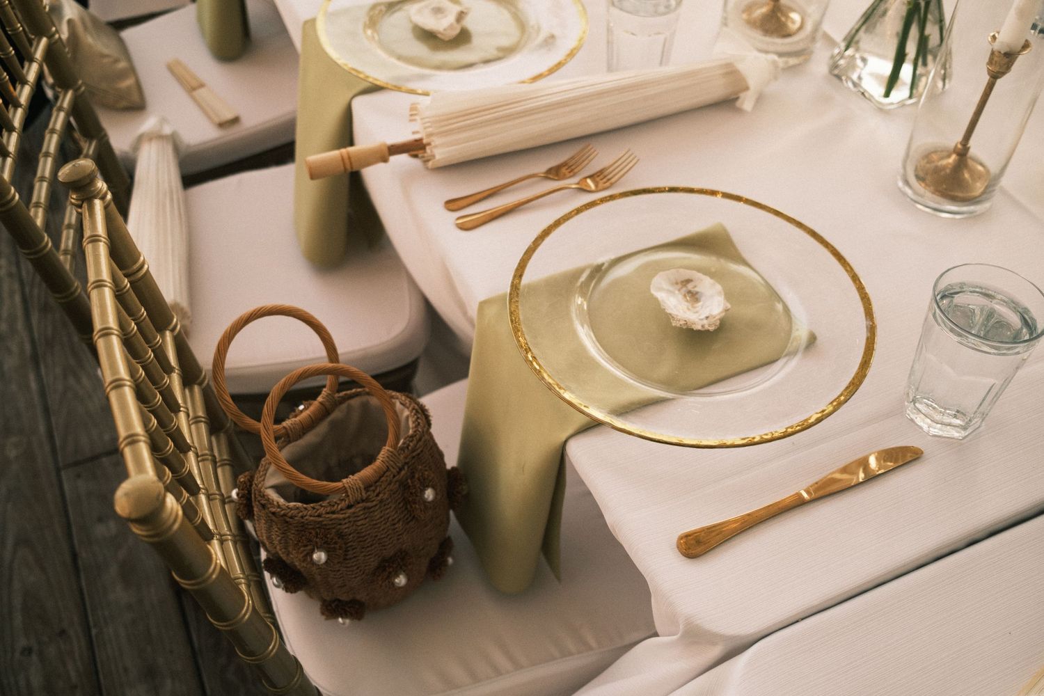 Elegant table settings with white linens and gold accents at a formal dinner.