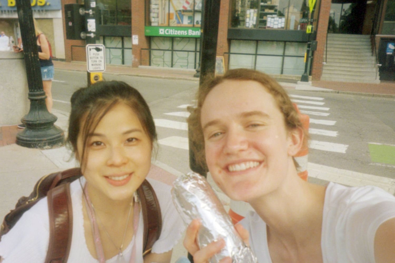 Two friends share water bottles while enjoying an outdoor adventure together.