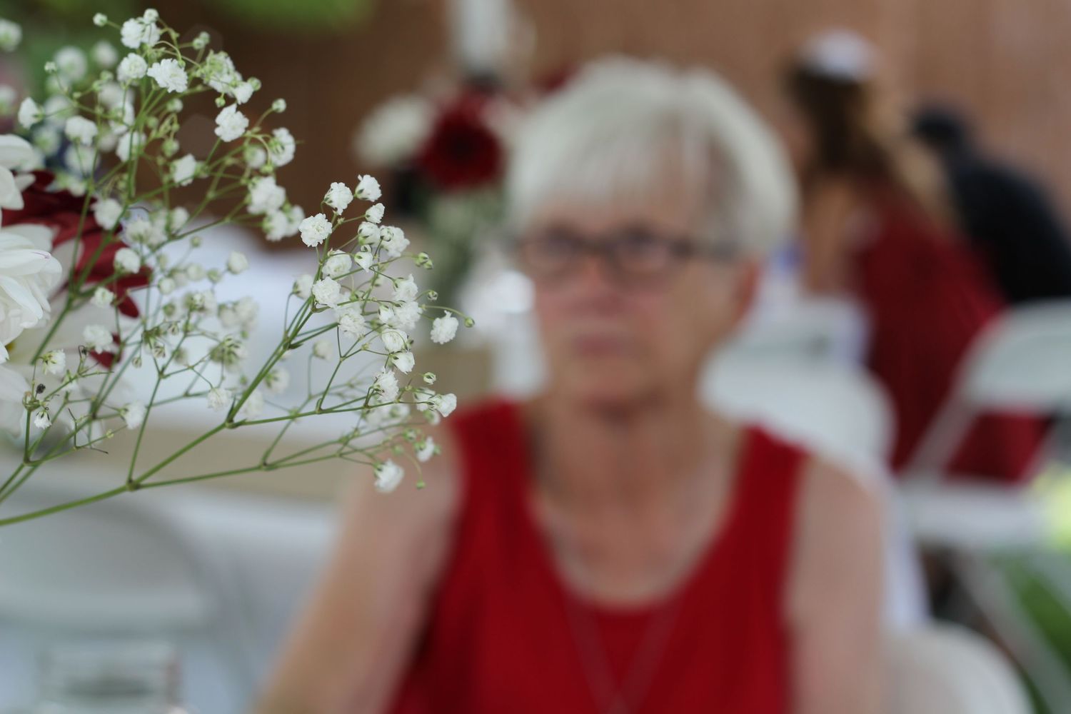 White baby's breath flowers in focus with blurred background at an indoor event.