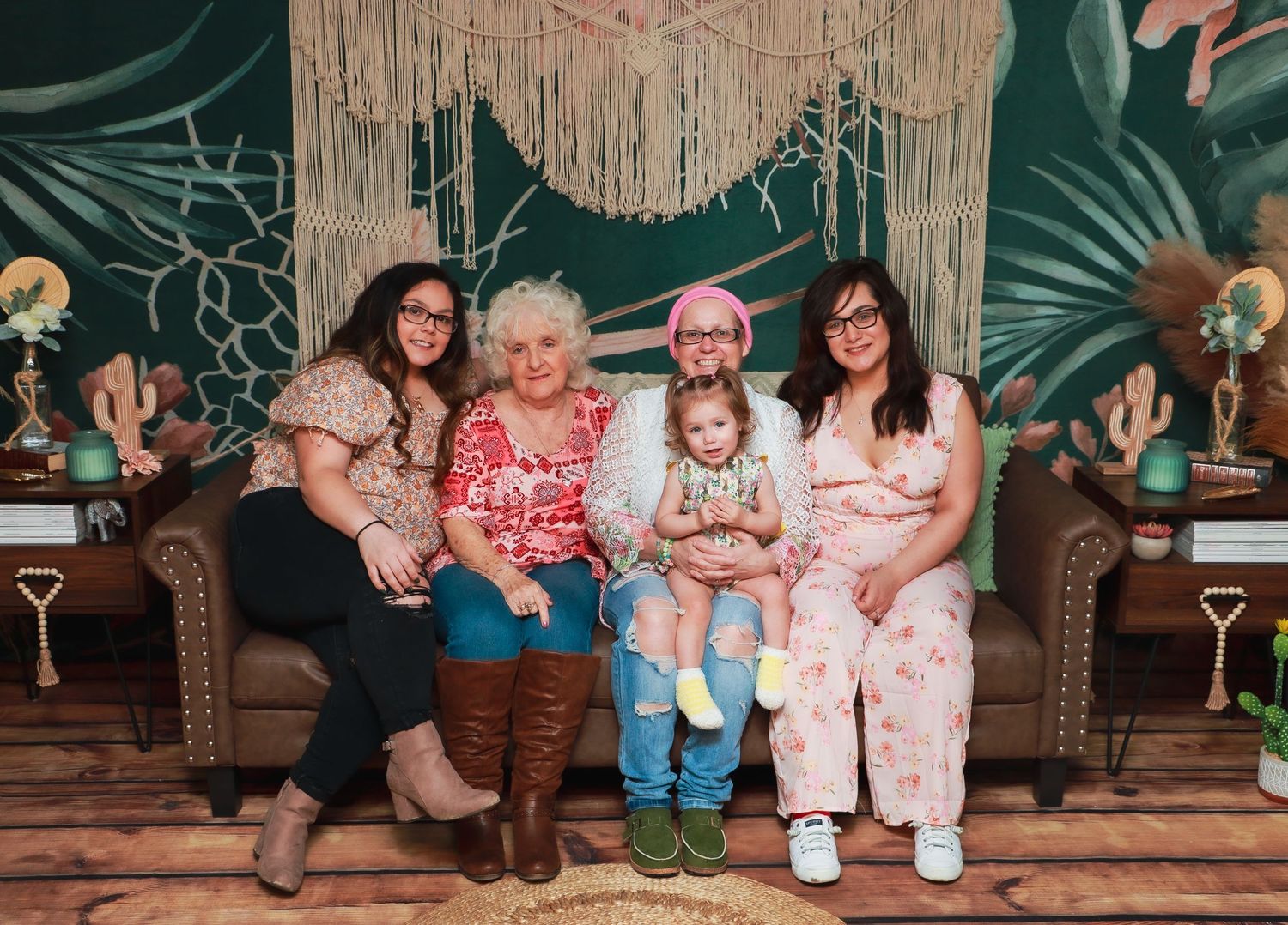 Casual group portrait against a boho-style backdrop with hanging decorations.