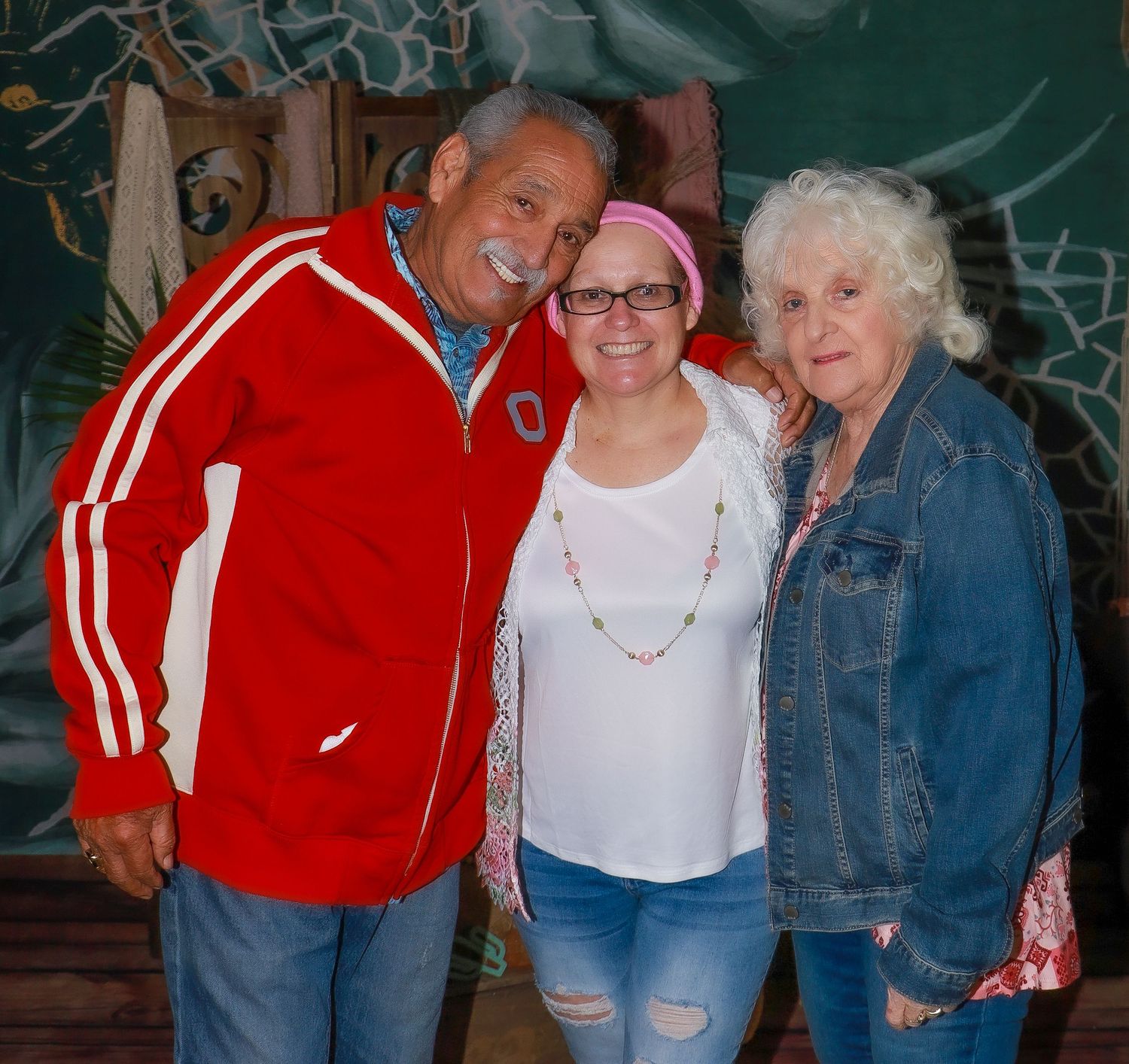 Group photo with person wearing bright red track jacket and denim.