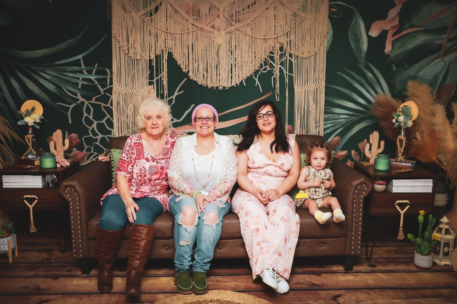 Group photo session with decorative macrame backdrop and tropical greenery decor.