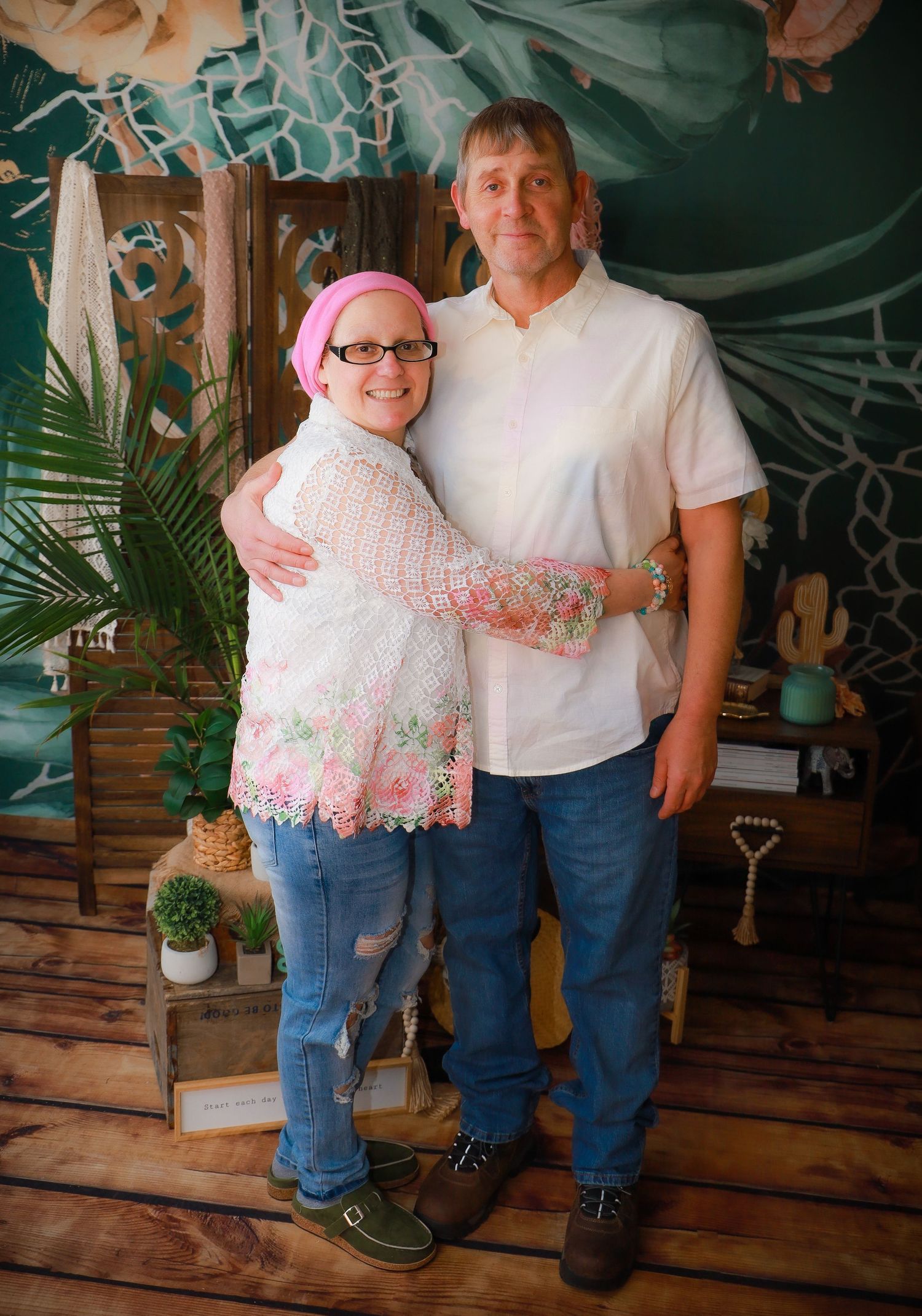 Casual group photo with white and pink outfits against decorative backdrop.