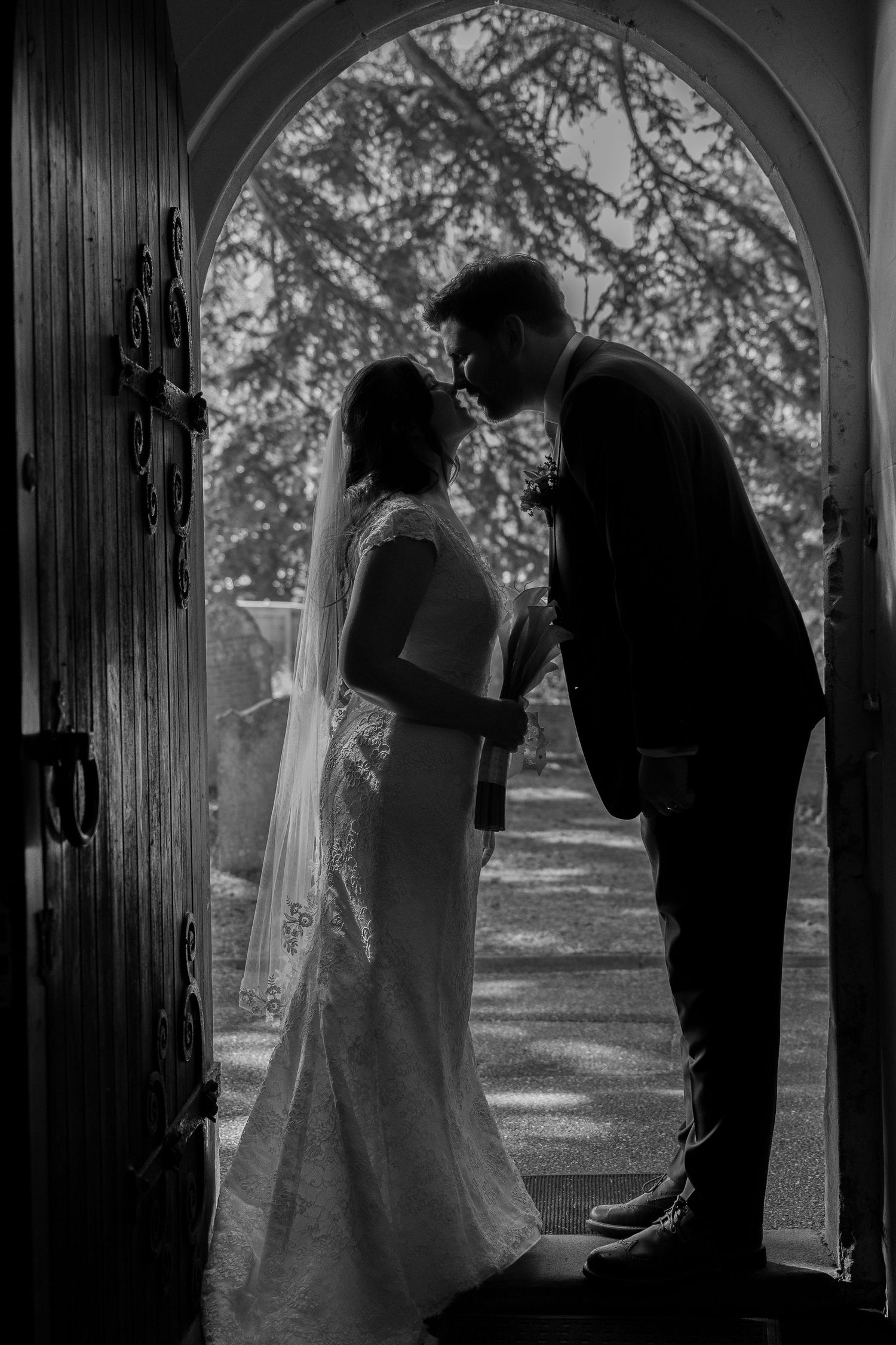 Wedding couple sharing a kiss in the church doorway - gavinhorrellphotography.com