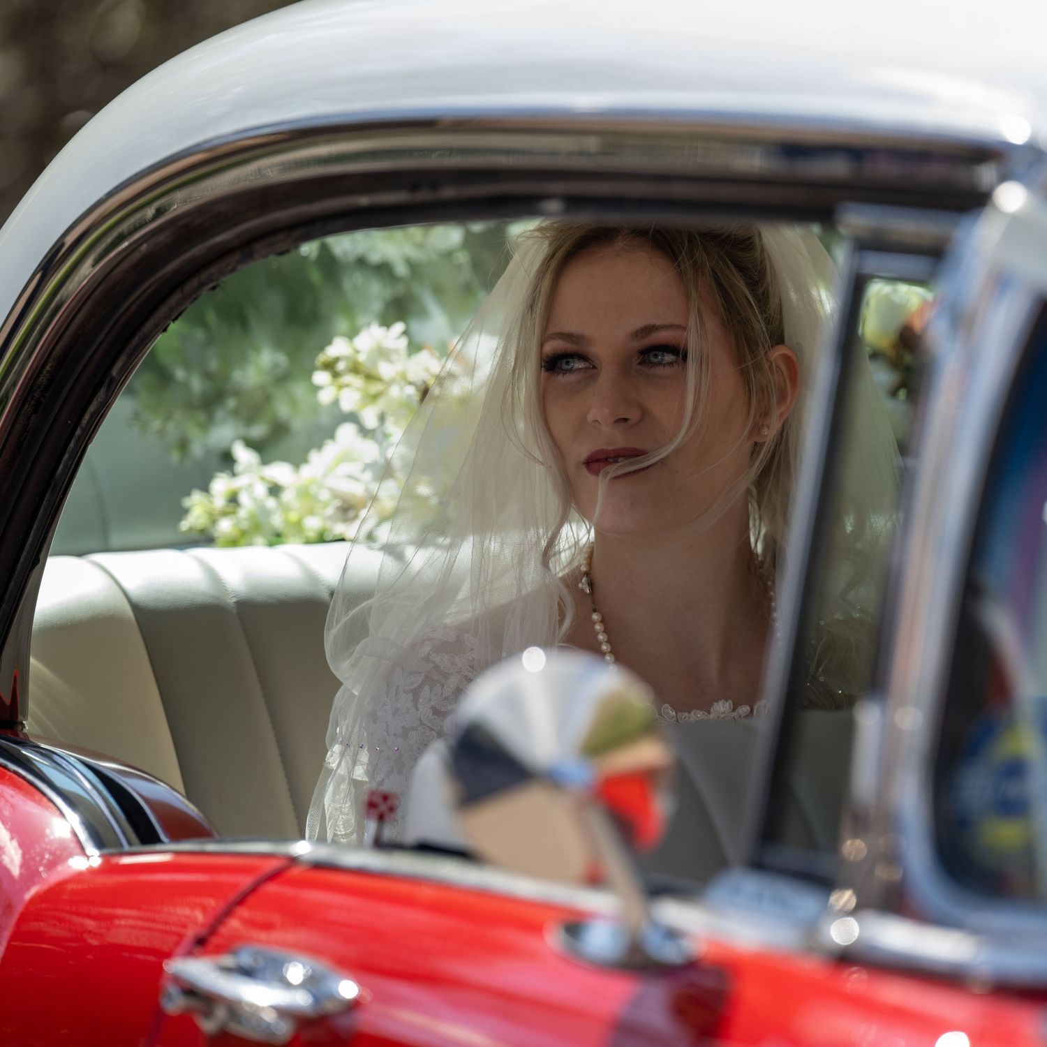 Bride’s arrival in the back of a red vintage car - Gavin Horrell Photography, South West England