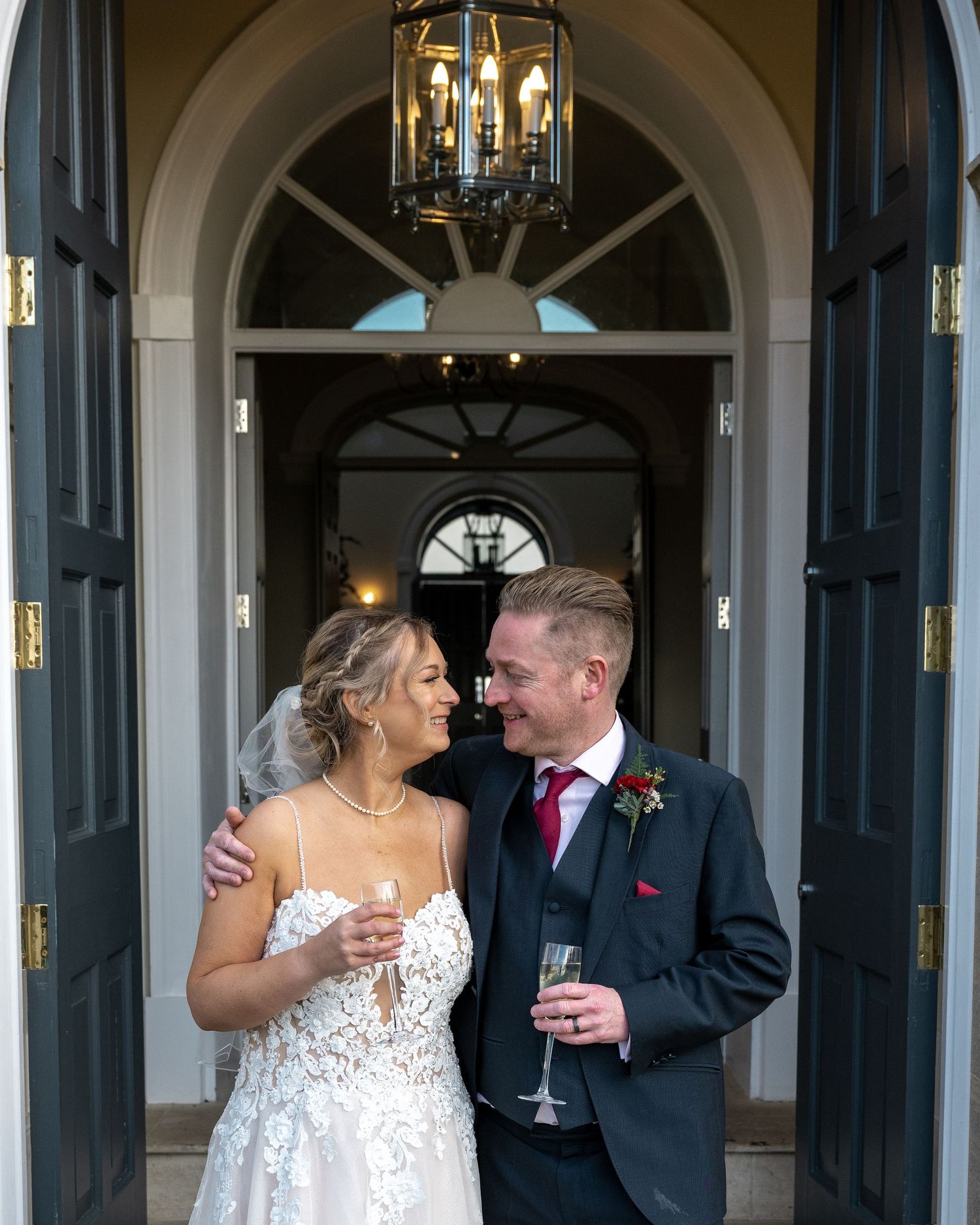 Bride and Groom with their wedding drinks in the hotel doorway - gavinhorrellphotography.com